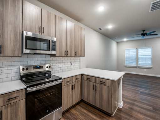 A modern kitchen with wooden cabinets and a stainless steel oven.