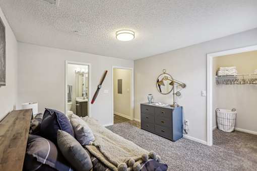 A bedroom with a bed, dresser, and mirror.