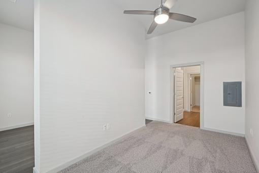A room with a ceiling fan and a carpeted floor.
