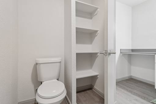 A white toilet is in a small bathroom with a white door.