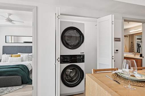 A modern laundry room with a washer and dryer built into the cabinetry.