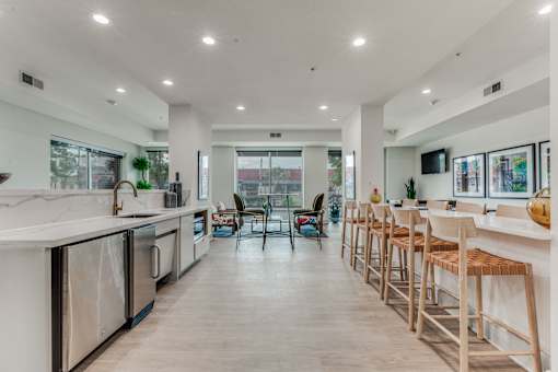 A modern kitchen with wooden floors and white countertops.