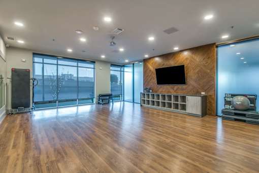A spacious room with wooden floors and a large window.