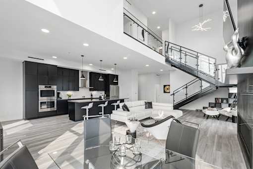 A modern kitchen with a glass table and stainless steel appliances.