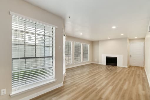 a living room with a fireplace and large windows