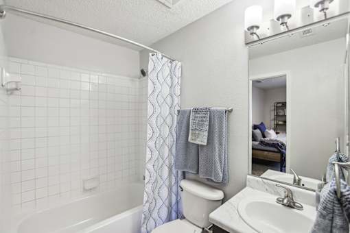 A white bathroom with a white tub, toilet, and sink.