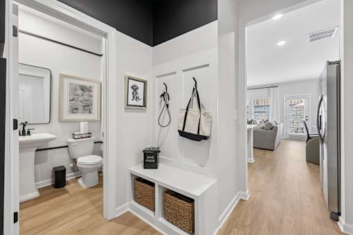 A bathroom with a toilet, sink, and a white wall.