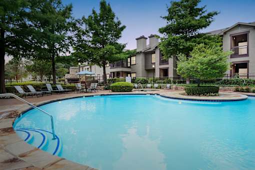 a swimming pool with an apartment building in the background
