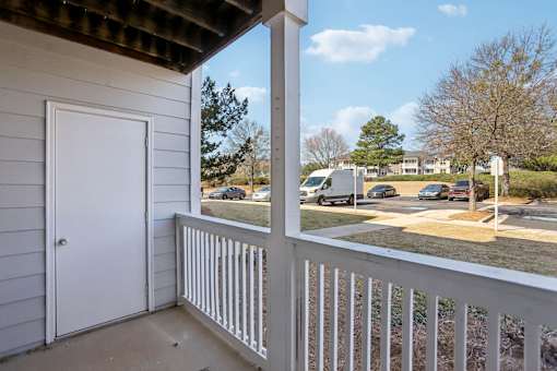 A view from a balcony overlooking a parking lot.