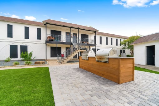 the backyard has a bar and a patio with a grill