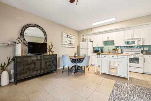 A kitchen with a dining table and chairs.