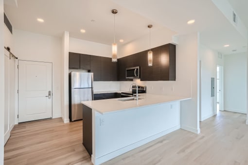 a kitchen with a large center island with a sink and a stove