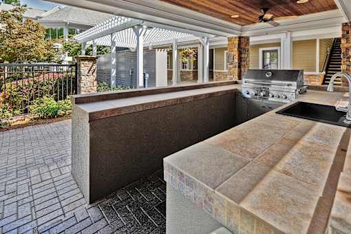 A patio with a grill and a sink.