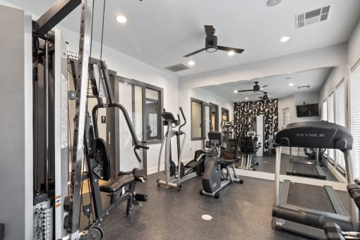 a gym with weights and cardio equipment in a home for sale