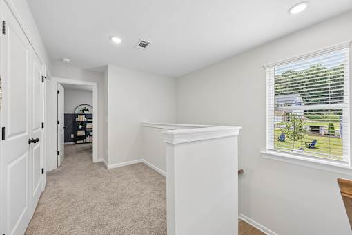 A white room with a window and a door leading to another room.