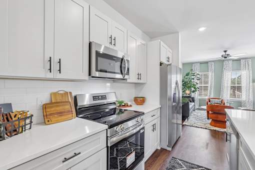 A modern kitchen with white cabinets and stainless steel appliances.