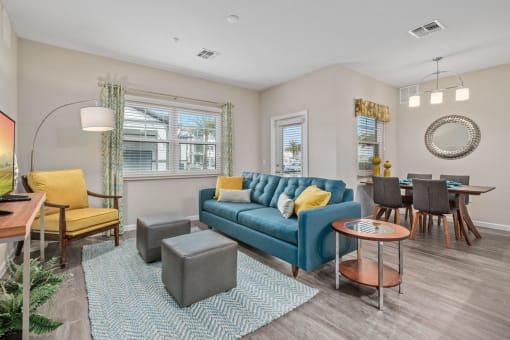 a living room with a blue couch and a dining room table