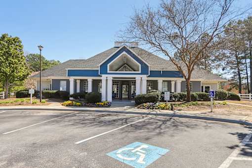 A parking lot with a handicap parking space in front of a building.