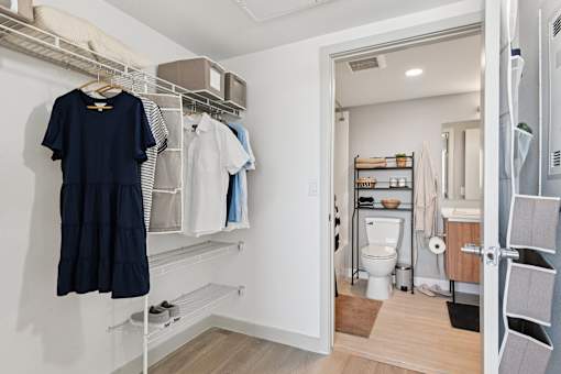 A white closet with a towel hanging on the rack.