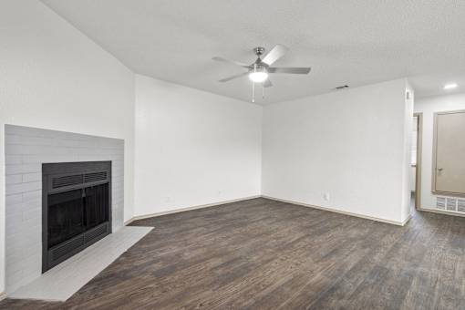 A room with a fireplace and a ceiling fan.