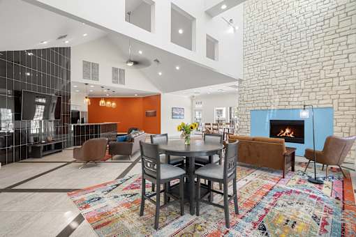 A modern living room with a brick wall and a fireplace.