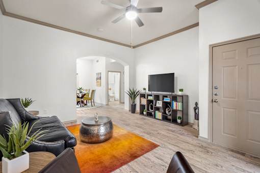 A living room with a black leather couch and a television.
