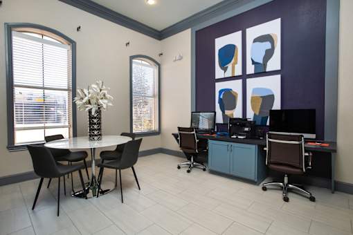 A room with a table, chairs, and computers.