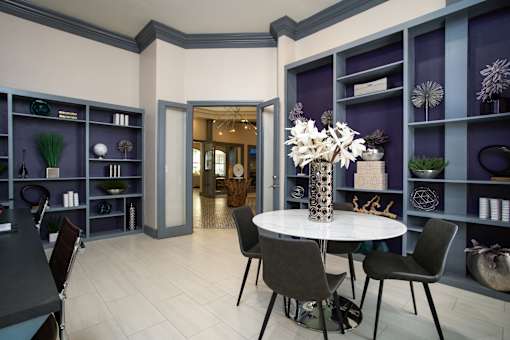 A dining room with a white table and chairs.