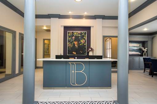 A reception desk with a gold letter B on it.