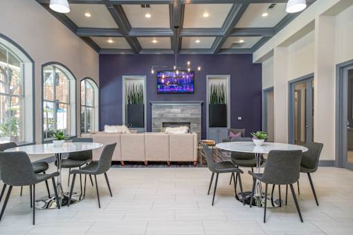 A modern dining room with a fireplace and a TV above it.