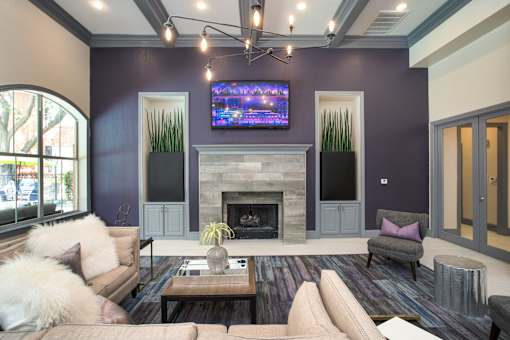 A living room with a fireplace and a flat screen TV mounted above it.