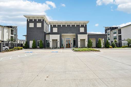 A modern building with a flat roof and a large front yard.