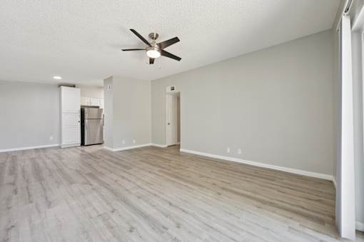 A room with a ceiling fan and lighting fixture.