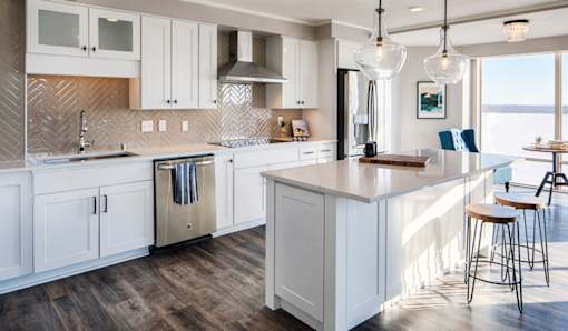 A kitchen with white cabinets and a wooden island.
