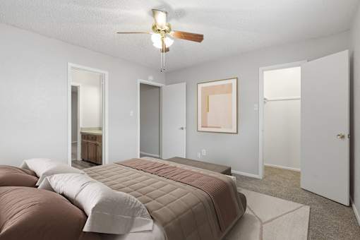 A bedroom with a bed and a ceiling fan.