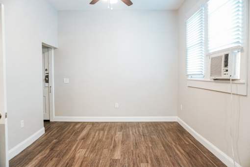 A room with wooden floors and a ceiling fan.
