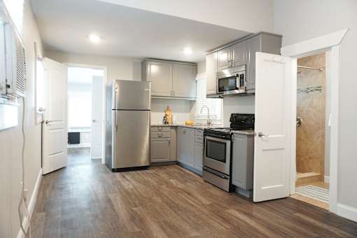 A kitchen with a refrigerator, oven, and microwave.