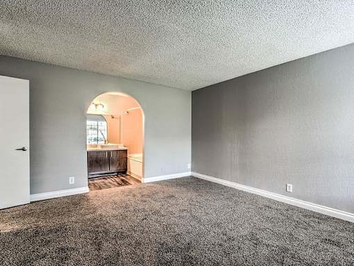 A room with a carpeted floor and a white door.