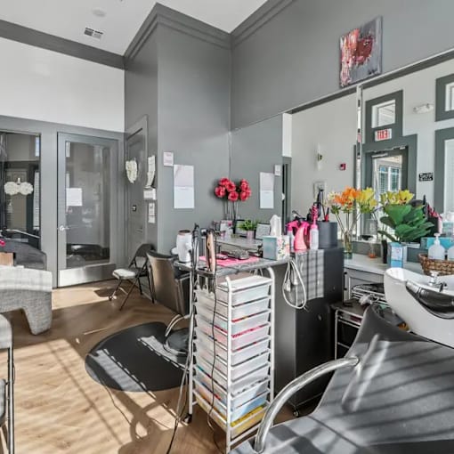 A salon with a black chair and a sink.