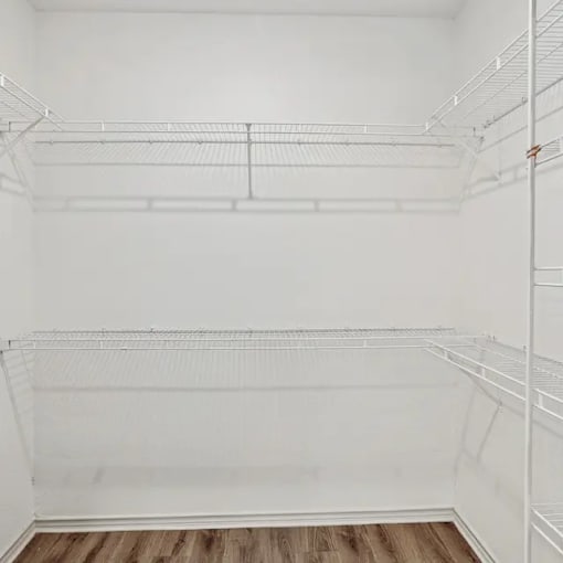 A white empty refrigerator with wooden flooring.