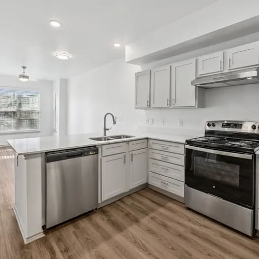 A modern kitchen with stainless steel appliances and white cabinets.