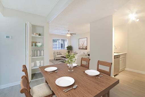 A dining room with a wooden table set for two.