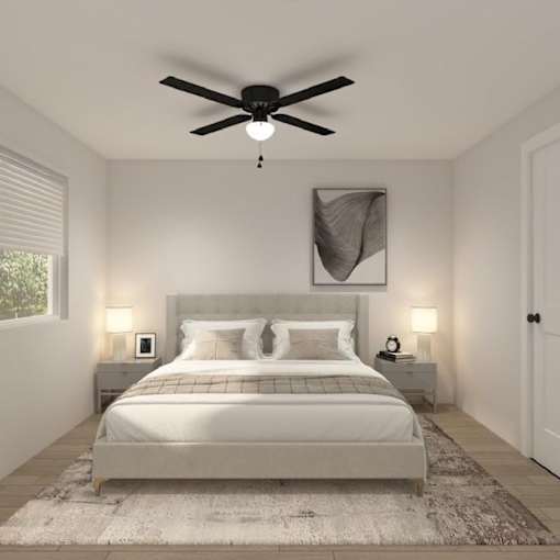A bedroom with a large bed and a ceiling fan.