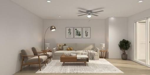 A modern living room with a white sofa, a wooden coffee table, and a ceiling fan.