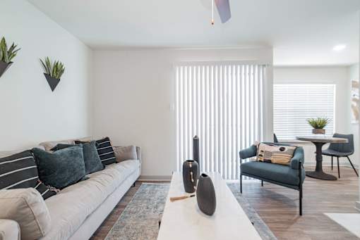 A living room with a white couch and a blue chair.