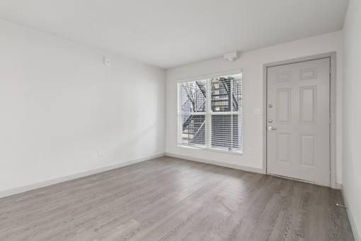 A room with a white door and a window with blinds.