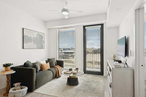 A living room with a grey couch, a coffee table, and a painting on the wall.