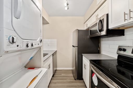 a kitchen with white cabinetry and black appliances