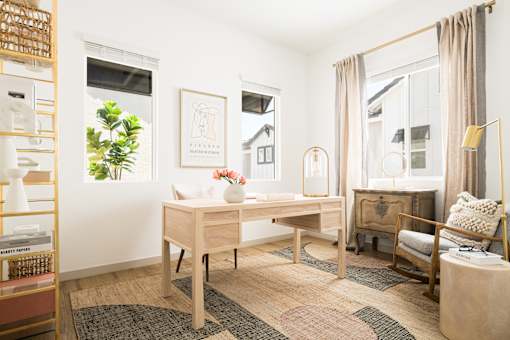 A room with a desk, chair, and a shelf with various items.