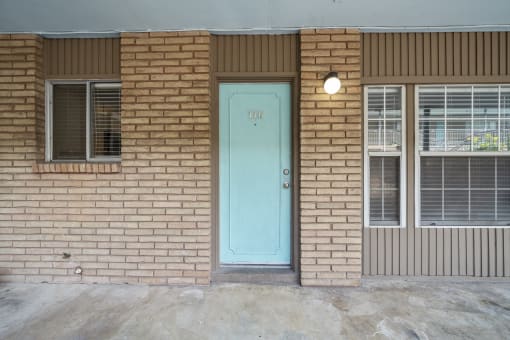 the front of a brick building with a blue door